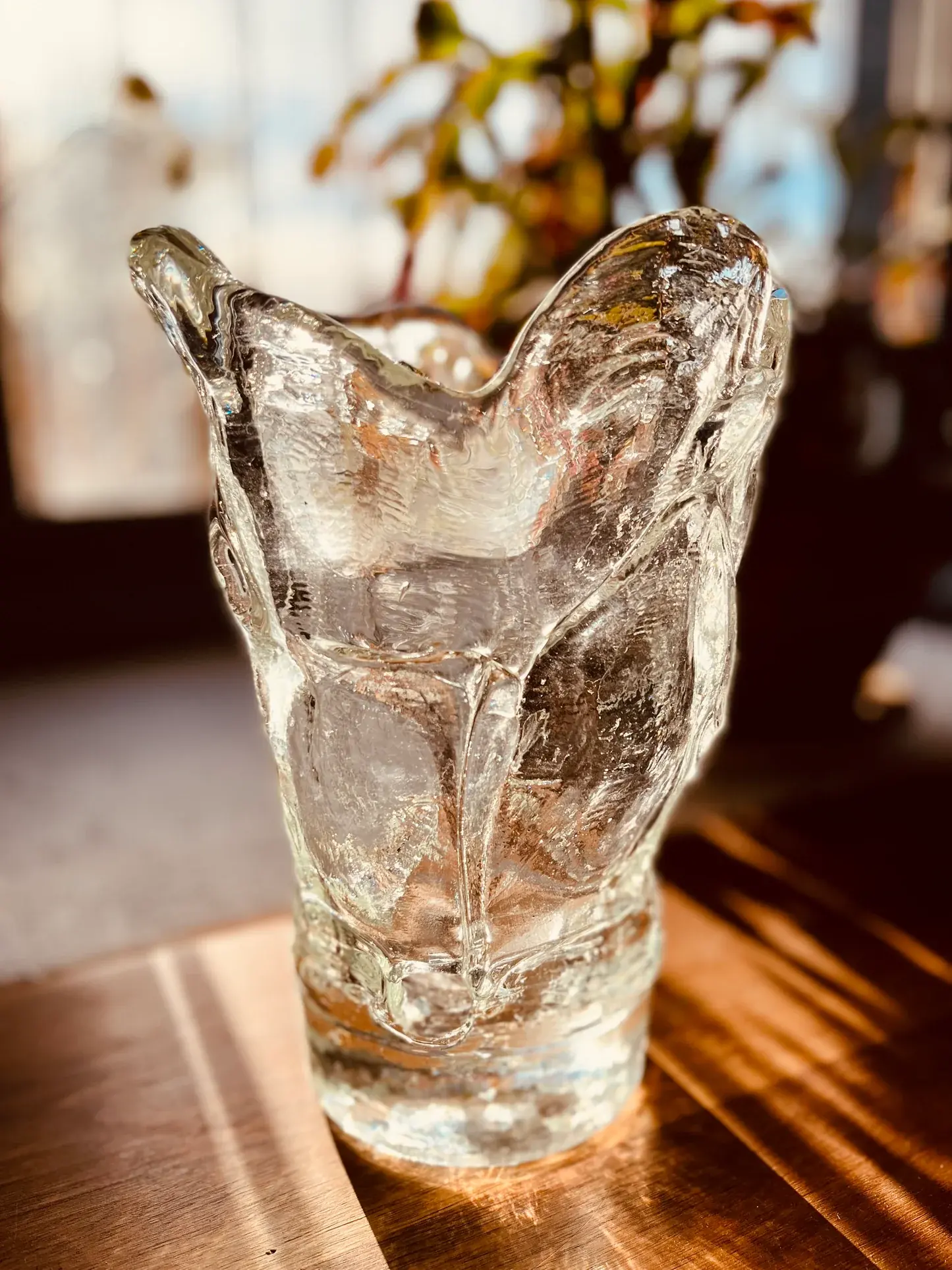 Glass orchid vase with orchid stems arranged in a natural interior setting